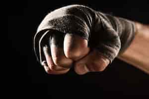 Free photo close-up hand with bandage of muscular man training kickboxing  on black