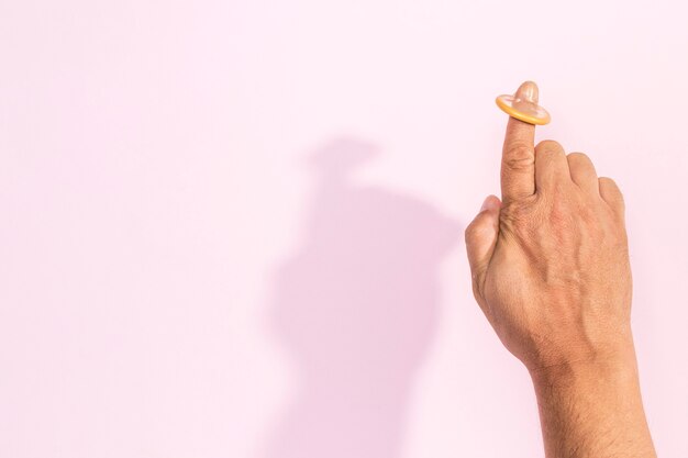 Close-up hand with condom on the index finger