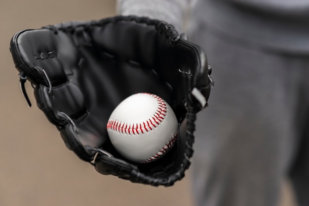 Close-up of hand with glove holding baseball