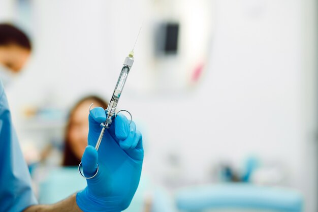 Close-up of hand with glove and syringe