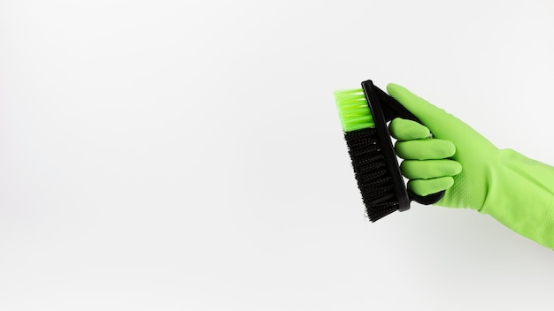 緑の手袋と黒のブラシでクローズアップ手