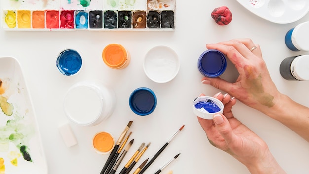 Free photo close-up hand with paint containers