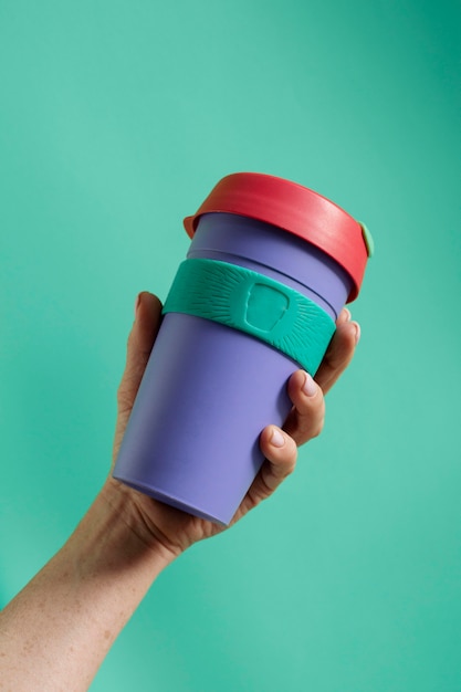 Foto gratuita primo piano a portata di mano con thermos riutilizzabili