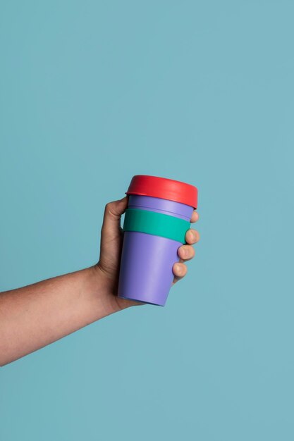 Close up on hand with reusable thermos