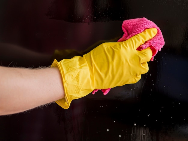 Close-up hand with rubber glove cleaning