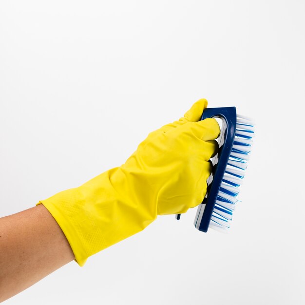 Close-up hand with yellow glove and brush