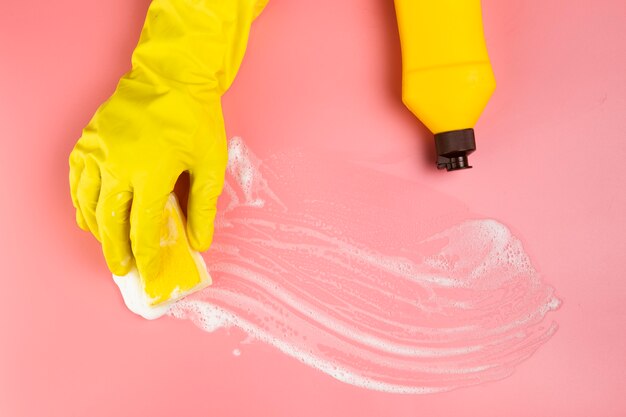 Close-up hand with yellow glove cleaning up