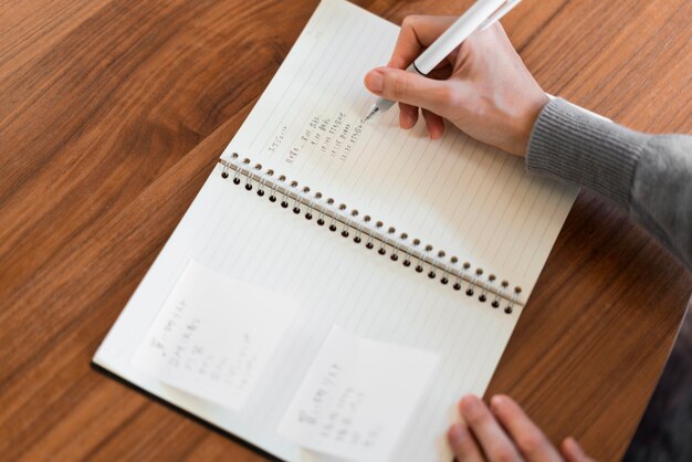 Close-up hand writing in notebook