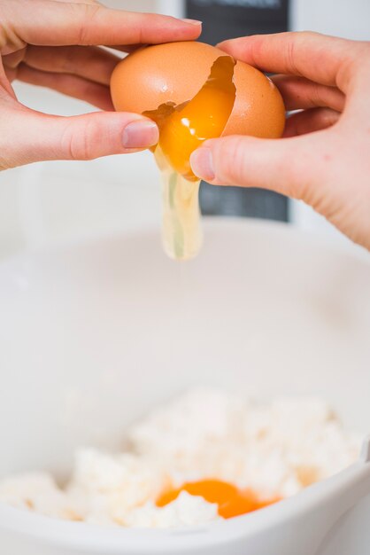 Close-up hands breaking egg