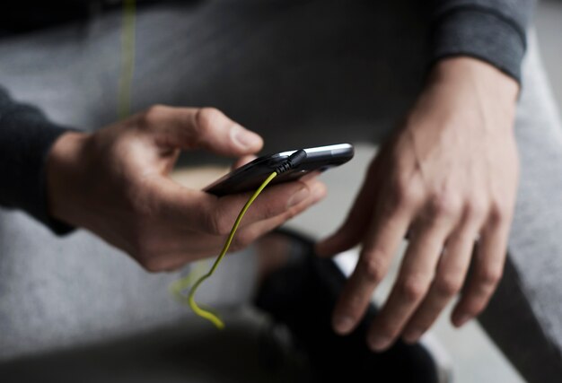 Close up on hands choosing a song on the phone