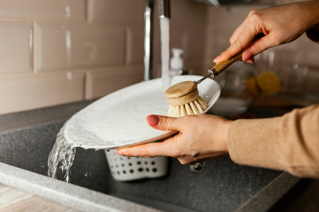 Close up hands cleaning plate