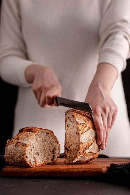 クローズアップ手ナイフでパンを切る