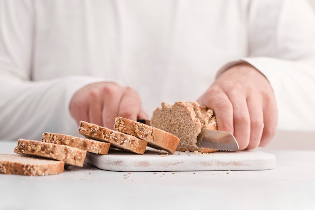 Close-up hands cutting bread