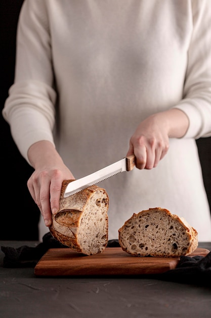 Close-up hands cutting bread