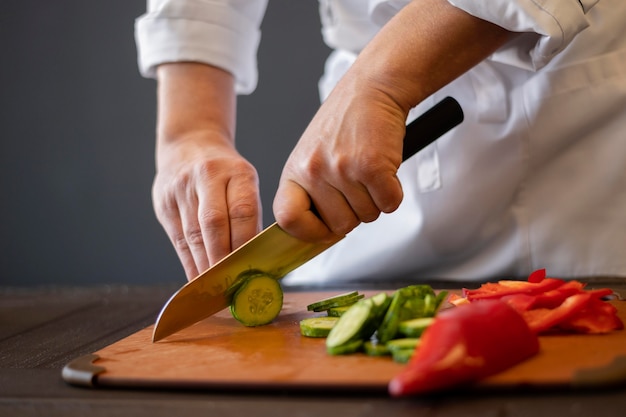 Free photo close-up hands cutting cucumber