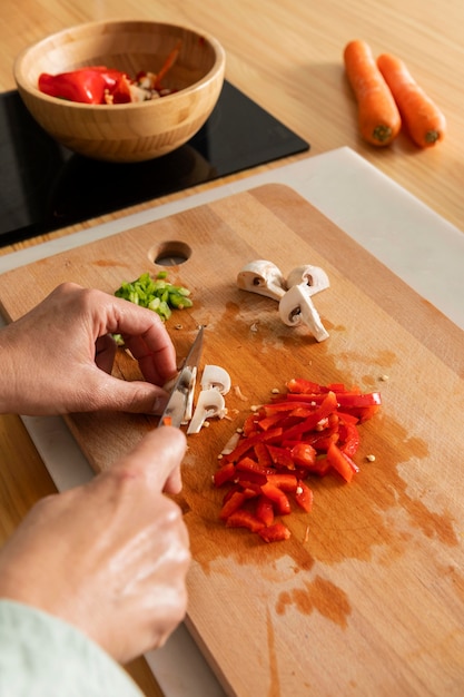 Free photo close up hands cutting pepper