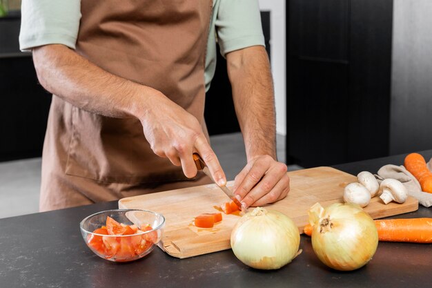 Close up hands cutting tomato