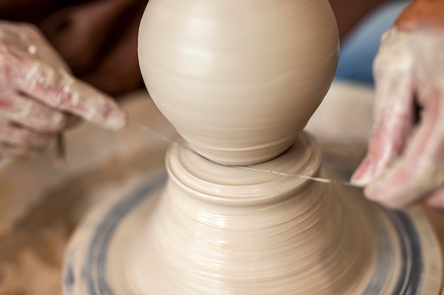 Foto gratuita chiudere le mani facendo la ceramica con il filo