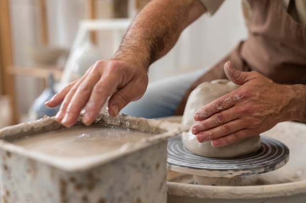 Free photo close up hands doing pottery