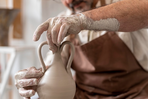 Free photo close up hands doing pottery