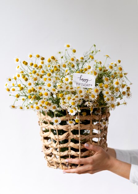 Close up hands holding basket with flowers