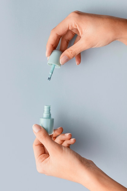 Close-up hands holding blue nail polish