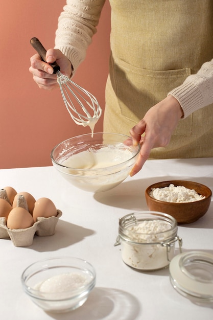 Close up hands holding bowl and whisk