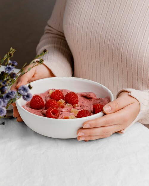 Close-up hands holding bowl with breakfast