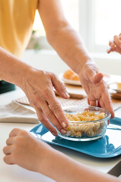 Close up hands holding bowl with pasta