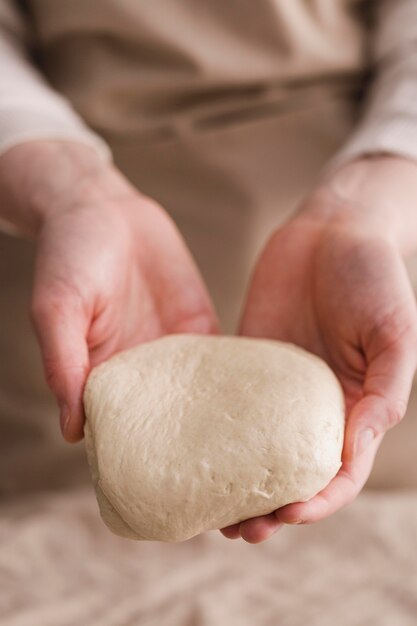 Close-up hands holding bread dough