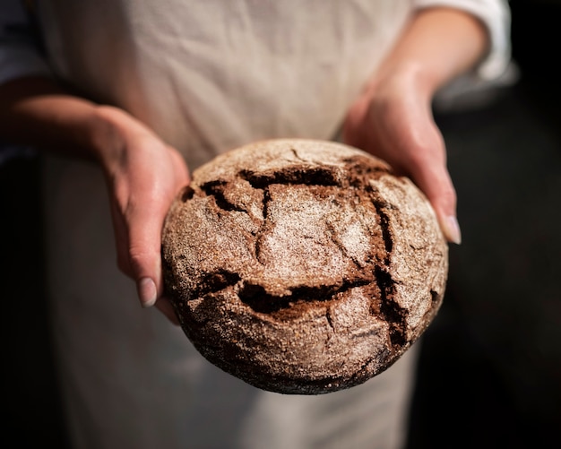 Free photo close up hands holding bread