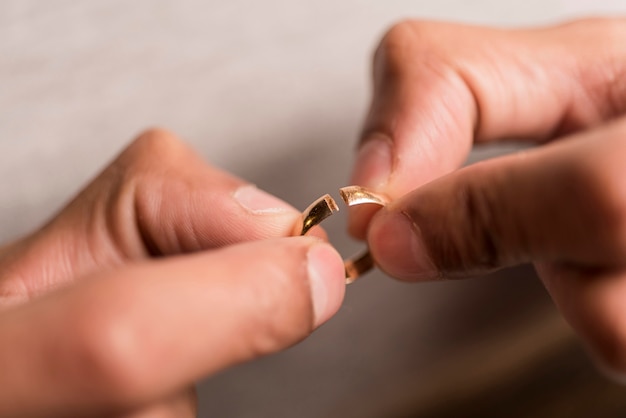 Close-up hands holding broken ring