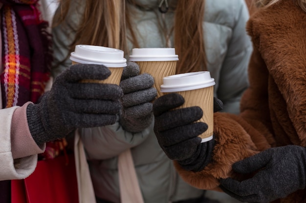 Foto gratuita mani del primo piano che tengono le tazze di caffè