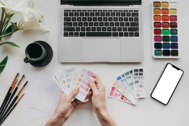 Close-up hands holding color palette cards