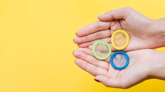 Close-up hands holding condoms with copy-space