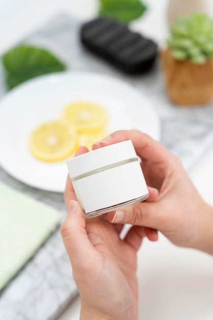 Close-up hands holding cream container