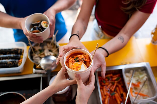 Free photo close up hands holding cup with food