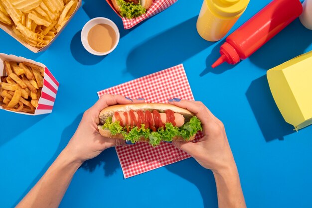 Close up hands holding delicious hot dogs