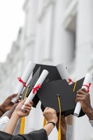 Close up hands holding diplomas and caps
