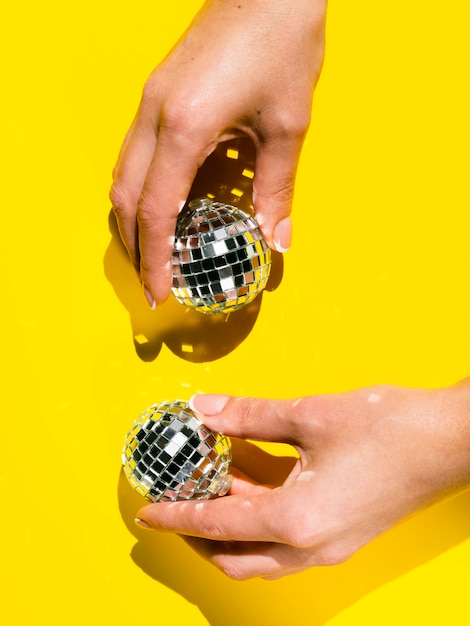 Free photo close-up hands holding disco globes