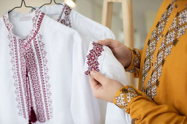 close up hands holding embroidered shirt