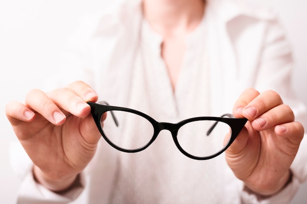 Close-up hands holding eyeglasses