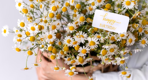 Close up hands holding flower bouquet with note