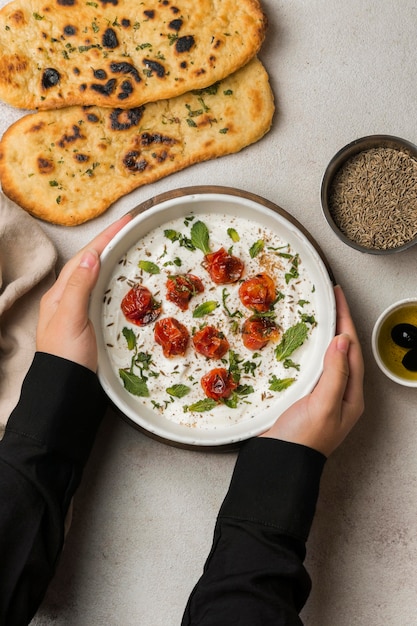 Foto gratuita mani del primo piano che tengono la ciotola del cibo