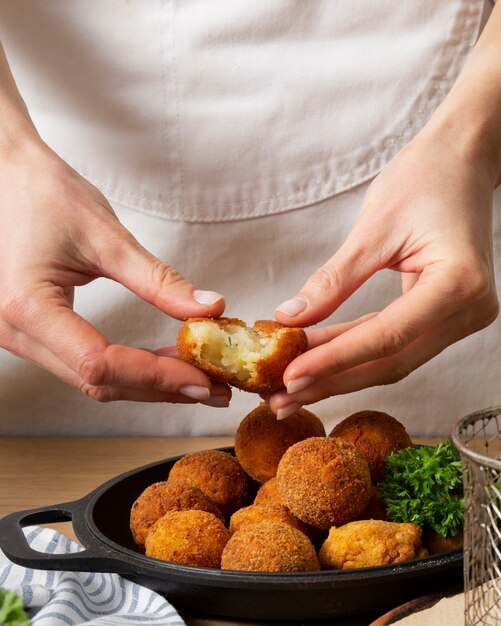 Close up hands holding food croquette