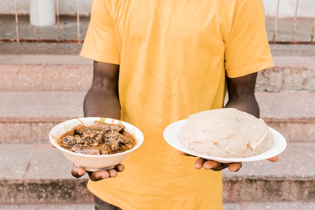 Бесплатное фото Крупным планом руки держат тарелки с едой