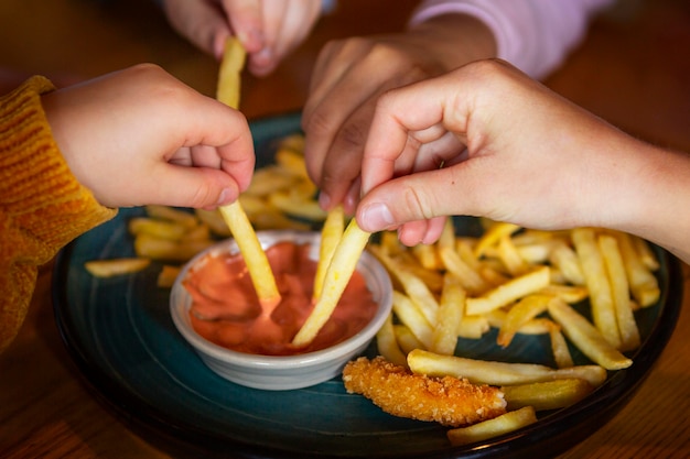 Free photo close up hands holding french fries