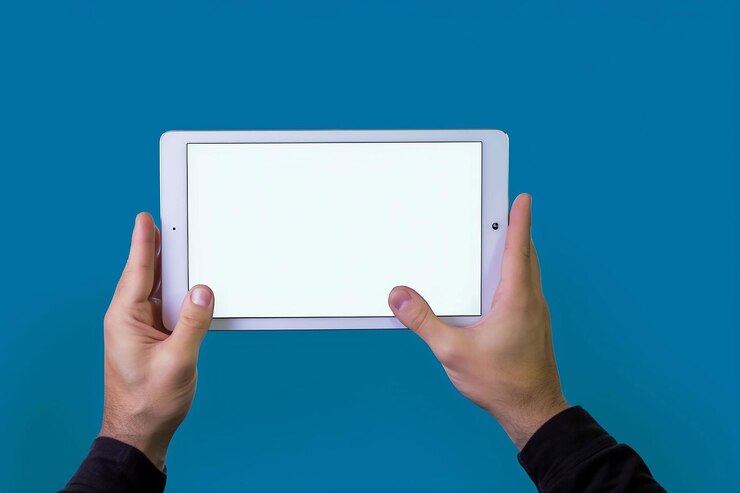Free Photo close up hands holding horizontal white ipad tablet