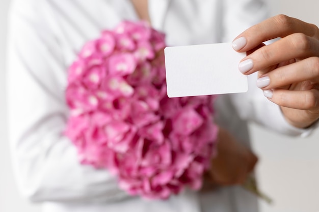 Free photo close up hands holding hydrangea bouquet and note