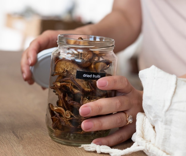 Close up hands holding jar with dried fruits